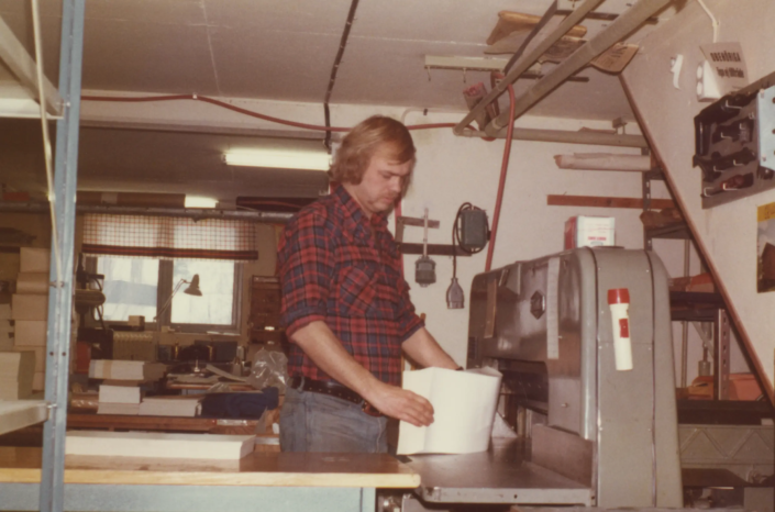 1980-tal. Sune Johansson förbereder en pappersbunt inför skärning i skärmaskinen.